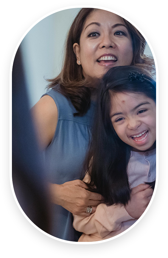 A woman and girl smiling for the camera.