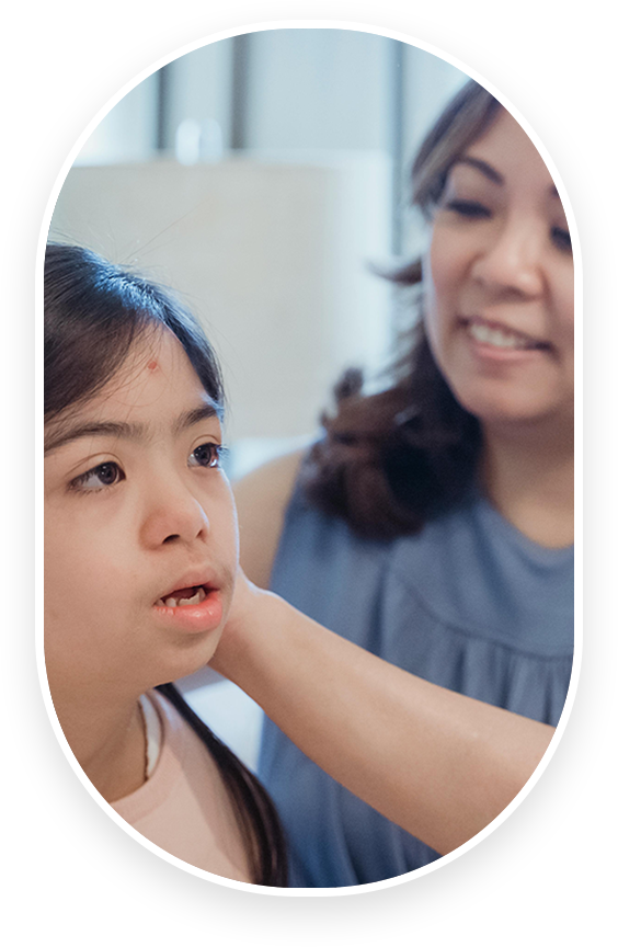 A woman is helping a young girl with her nose.